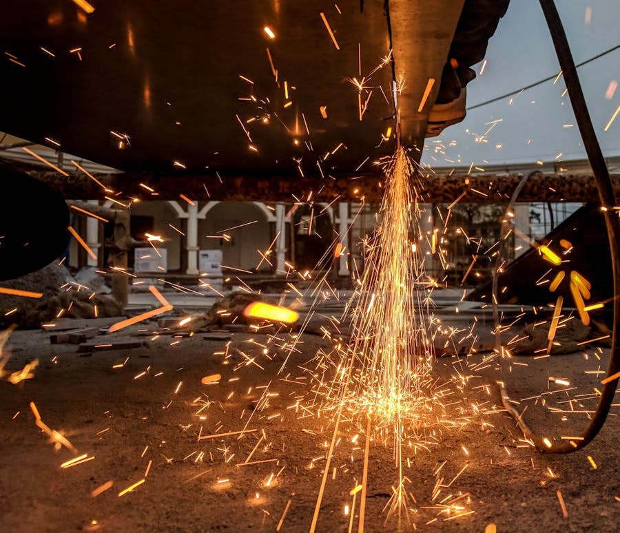 Lucru industrial pe metal cu scântei în atelier